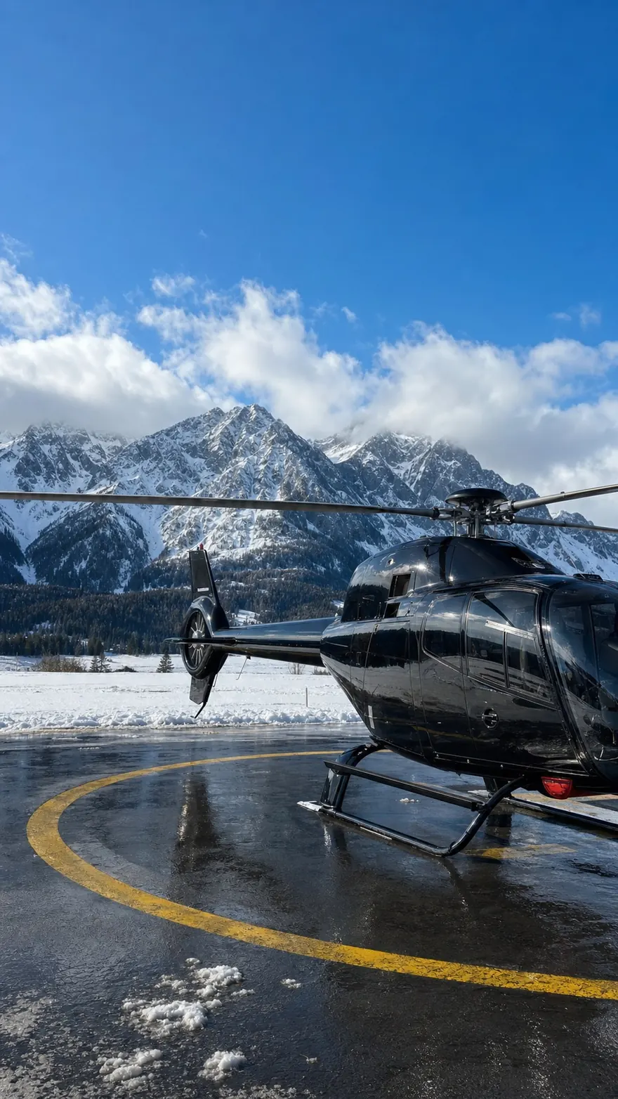 Alpine Helipad: Blacked-out helicopter on a wet pad below snowy peaks