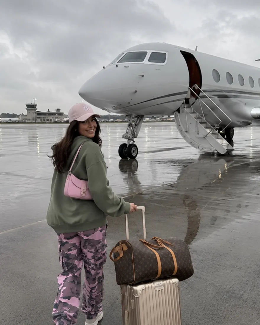 Private Jet Arrival: Rolling luggage across a rainy tarmac to a private jet