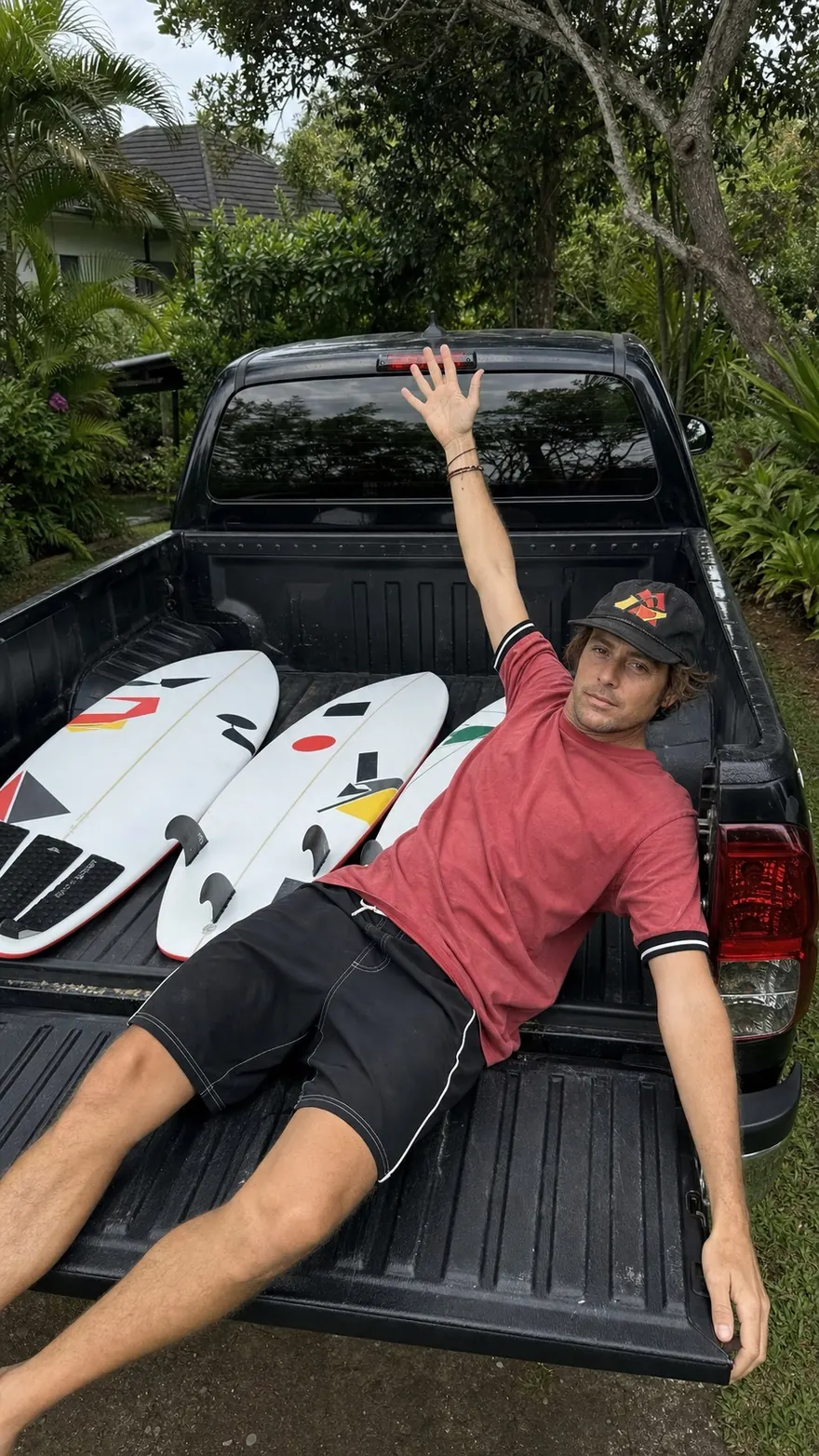 Tailgate Recline: Laid back across the open tailgate of a black pickup